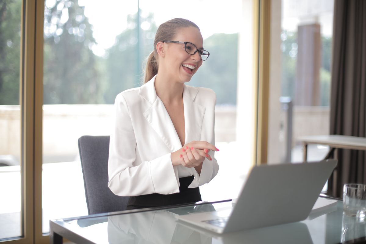 Sales professional smiling while working on a laptop